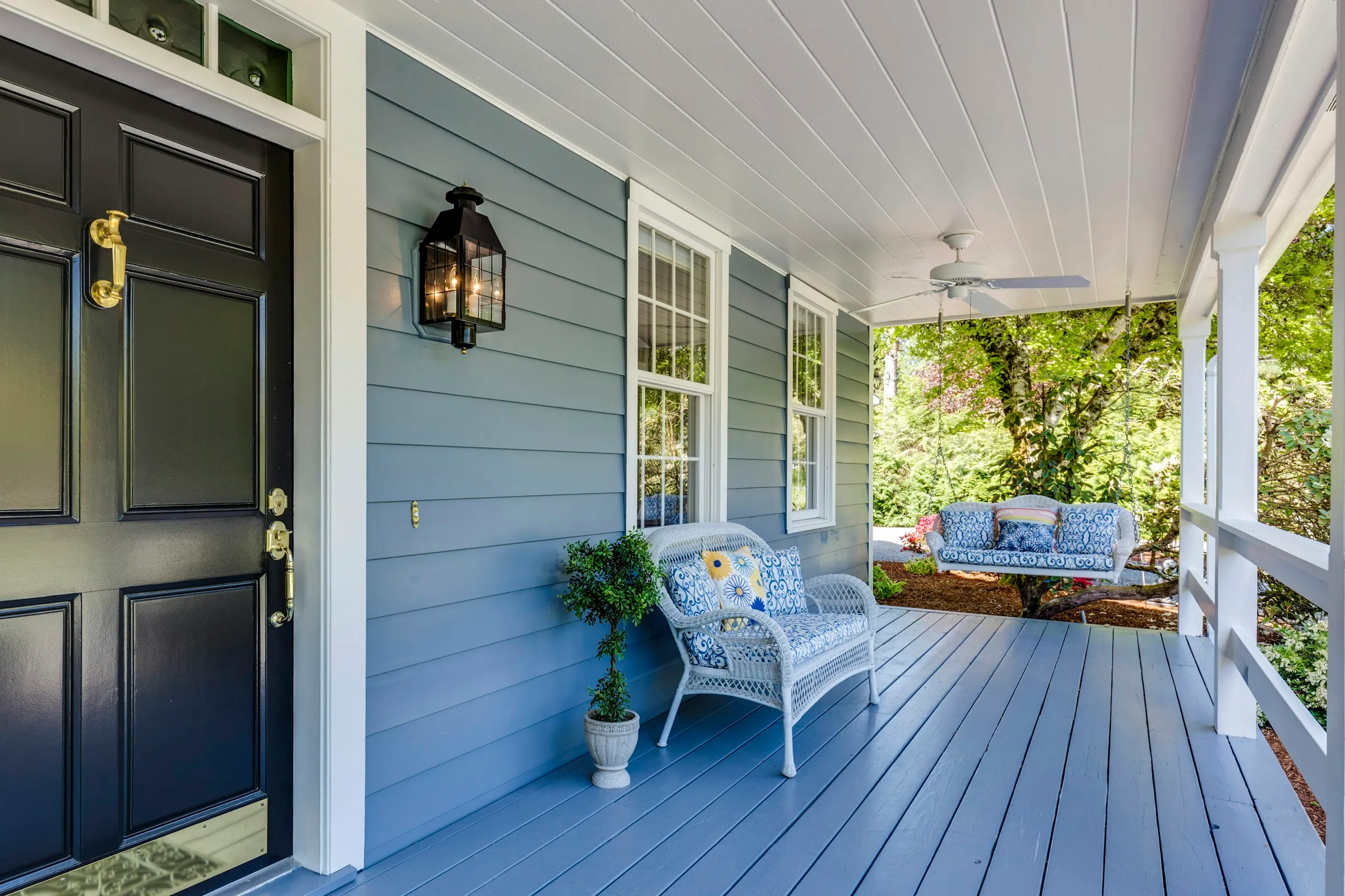 Freshly painted blue porch with a navy front door and white trim