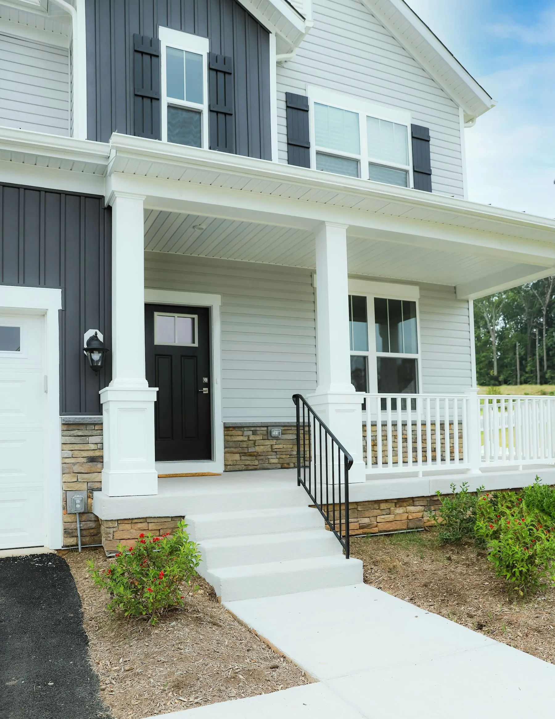 White painted front porch with columns and a black front door